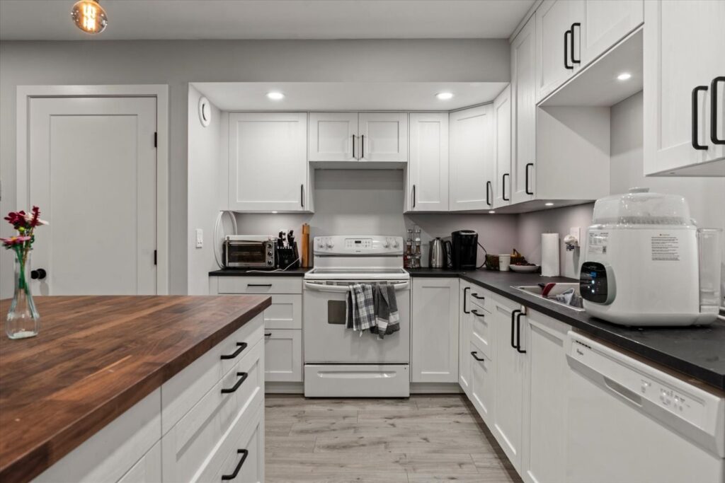 Kitchen with white cabinets and full size appliances at 915 34909 Old Yale Road