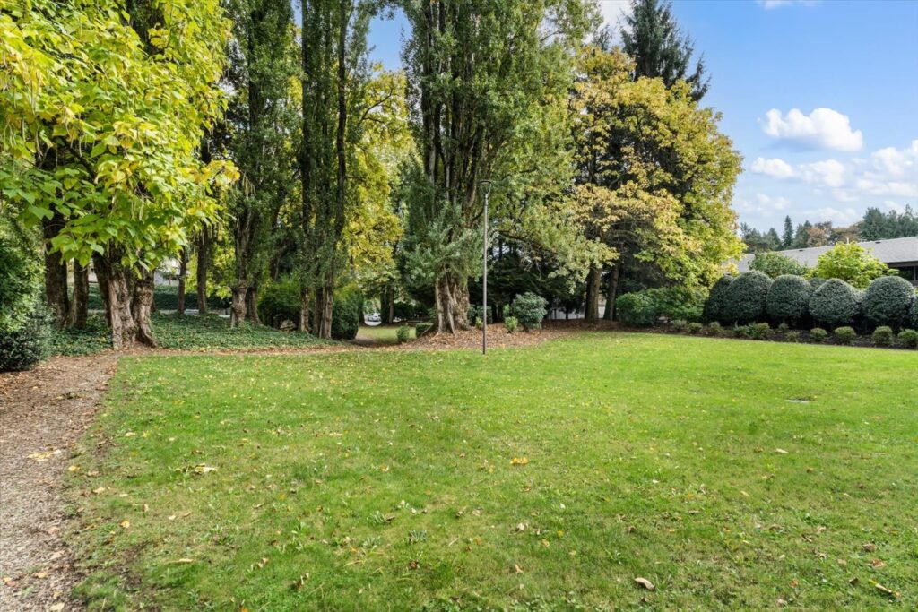 Lawn and mature trees on the grounds of The Gardens