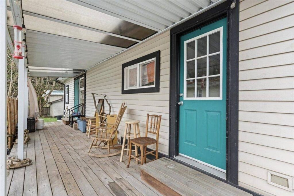 Covered porch and teal front door at 28 3942 Columbia Valley Road