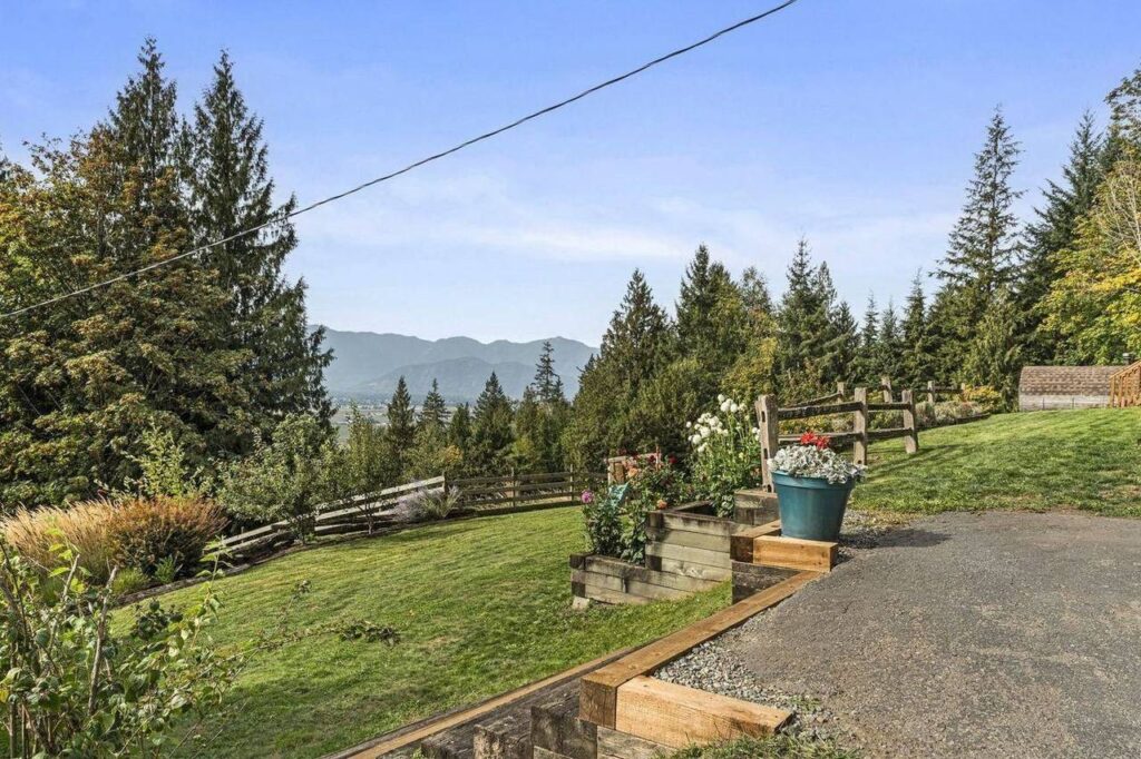 Garden beds and split rail fence with mountain views at 48625 Wincott Road