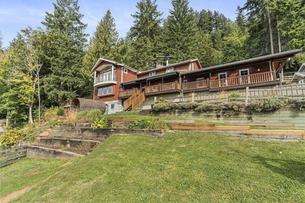 The main house at 48625 Wincott Road above terraced lawn and garden beds