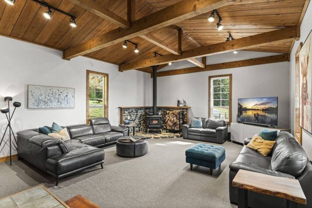 Living room under vaulted cedar with a wood stove at 48625 Wincott Road