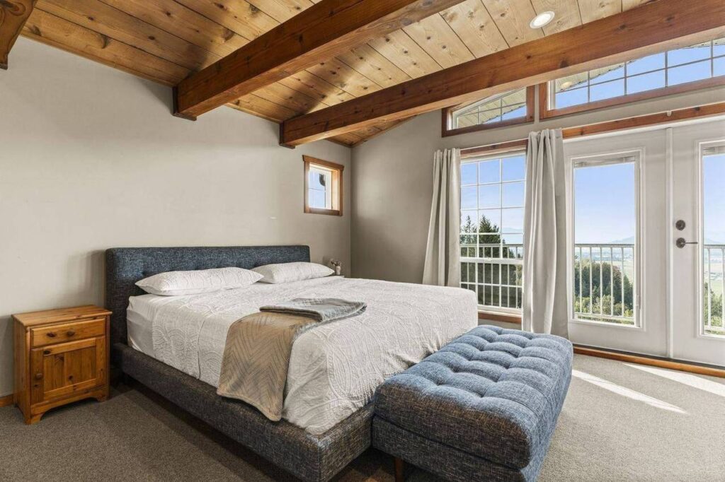 Primary bedroom with cedar ceiling and French doors at 48625 Wincott Road