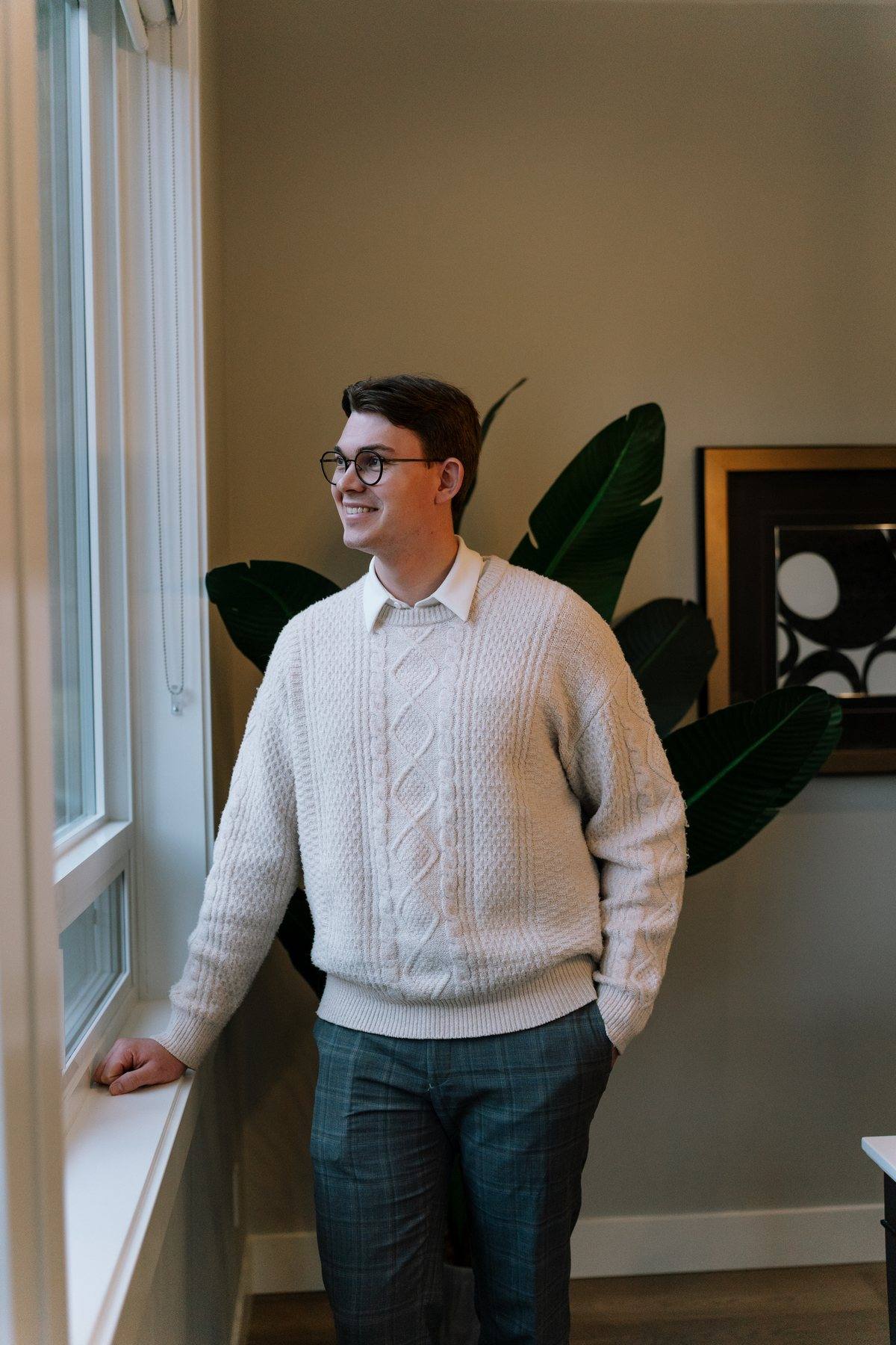 Nahum Hoeppner standing by the window of a Marble Hill home in Chilliwack