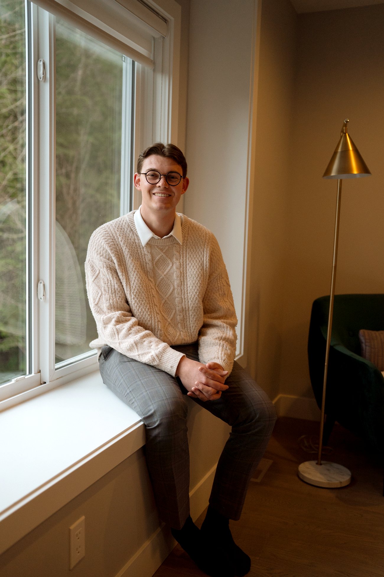 Nahum Hoeppner sitting in a window frame at a Marble Hill home in Chilliwack