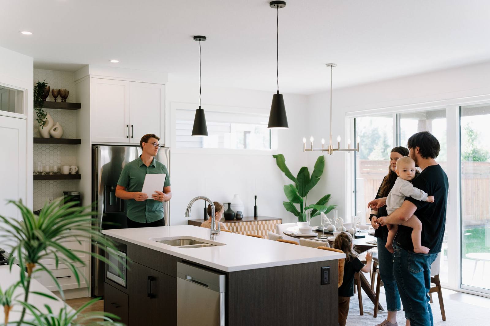 Nahum Hoeppner showing a young family through a kitchen